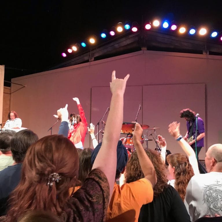 crow dances as band plays on stage.