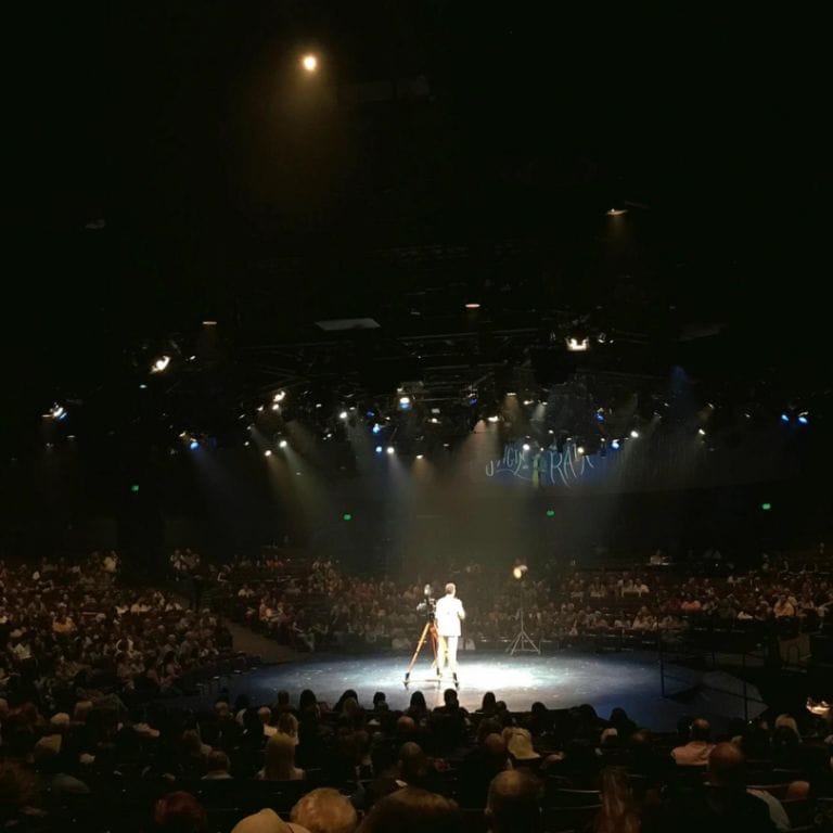 man on stage under spotlight