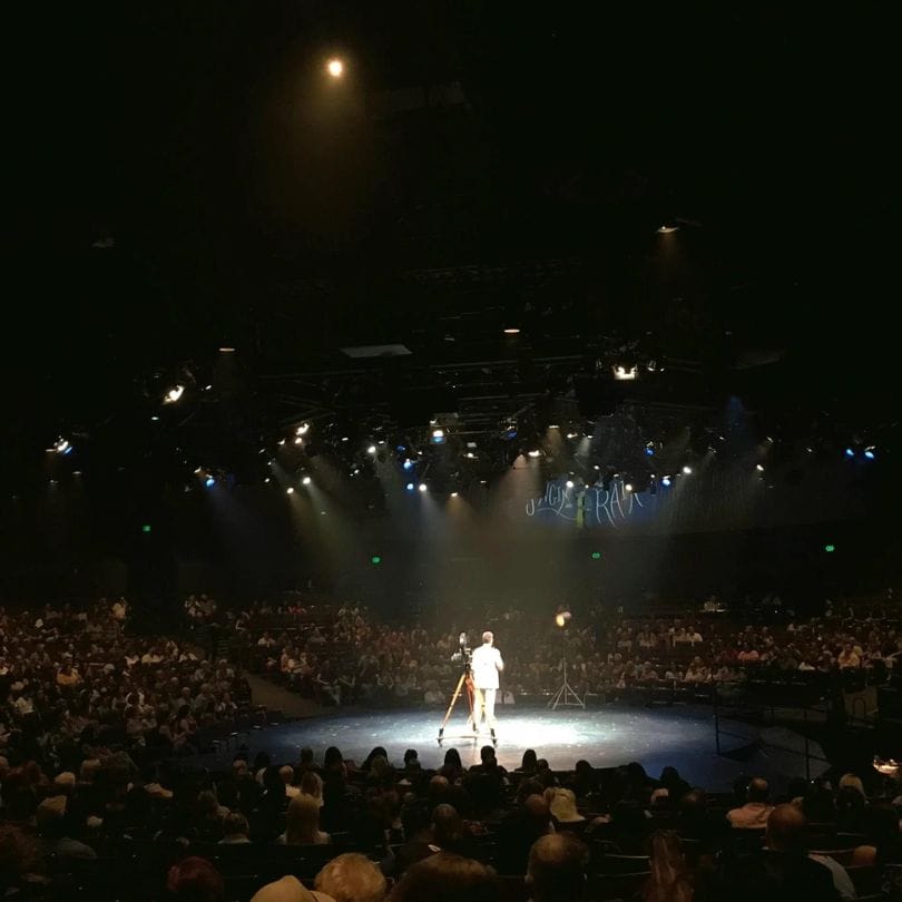 man on stage under spotlight