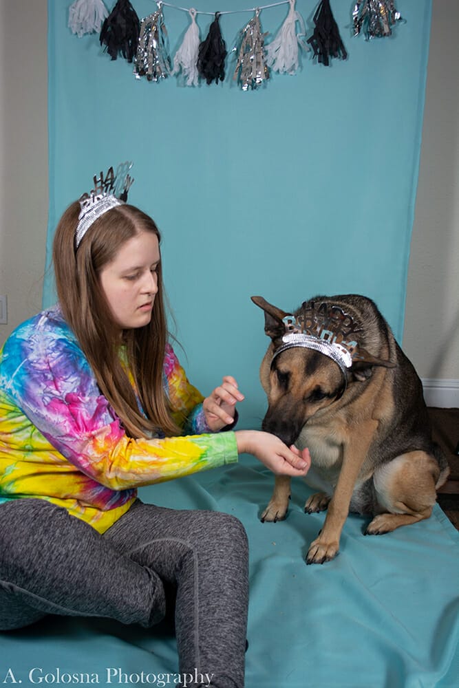 young woman wearing a tierra with her dog also wearing a tierra and getting a pet portrait