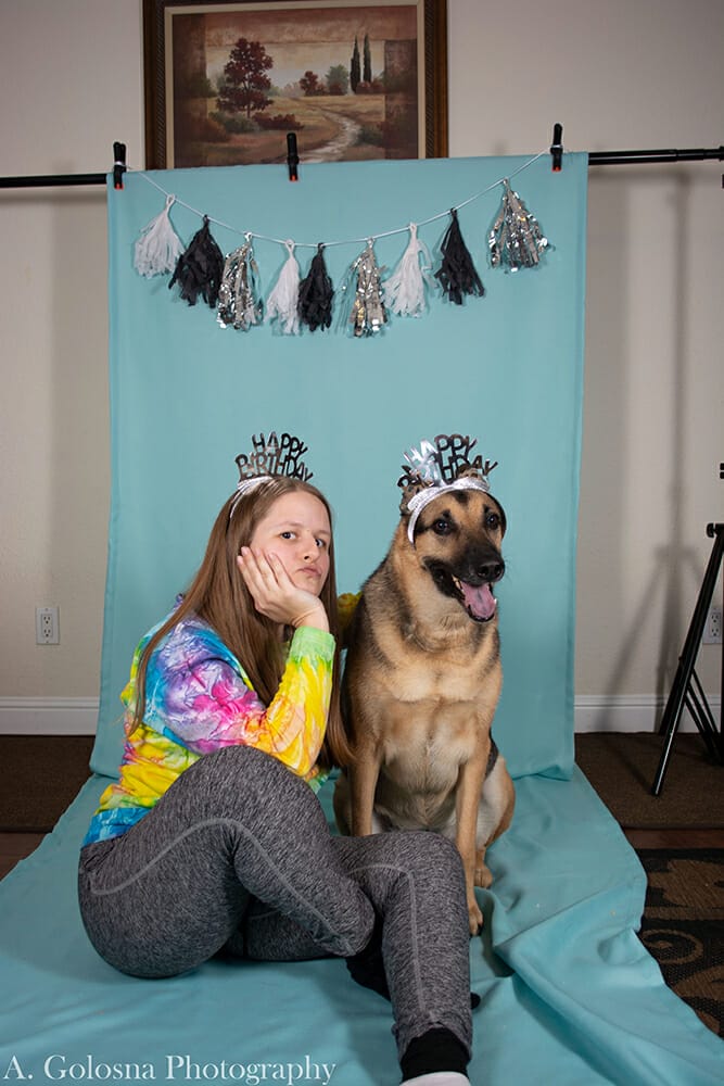 young woman wearing a tierra with her dog also wearing a tierra and getting a pet portrait