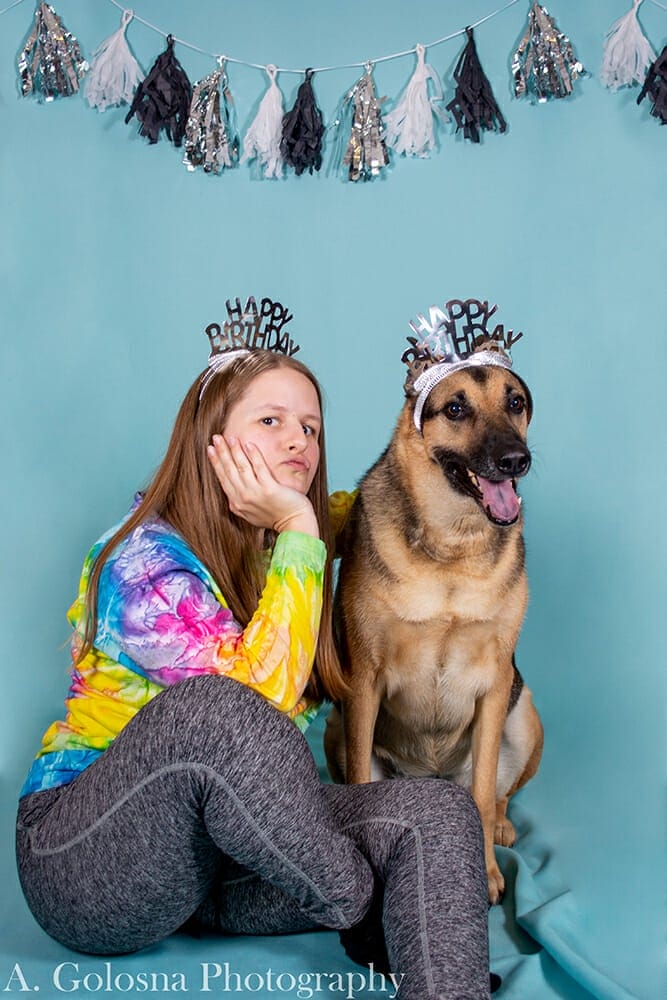 young woman wearing a tierra with her dog also wearing a tierra and getting a pet portrait