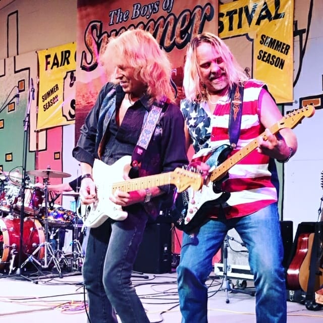 two guys playing guitars