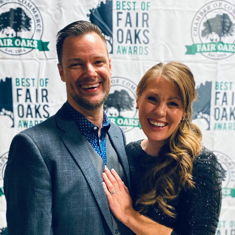 two people posing in front of chamber backdrop